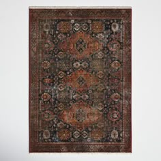 an antique rug with many different colors and patterns on it, hanging up against a white wall