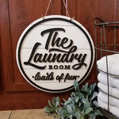 a sign that says the laundry room tastes of fun hanging on a wall next to towels