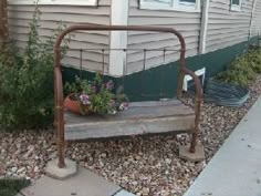 a wooden bench sitting in front of a house next to a flower potted plant