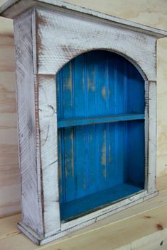 an old blue bookcase is sitting on a shelf