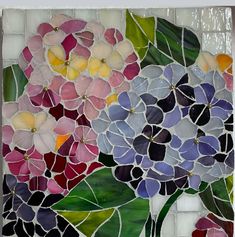 a glass mosaic with flowers and leaves on it