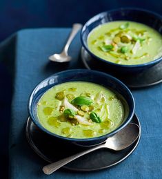 two bowls filled with soup on top of a blue table