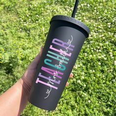 a person holding up a black tumbler cup