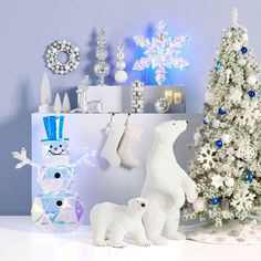 a white christmas tree next to a polar bear and snowman figurine set