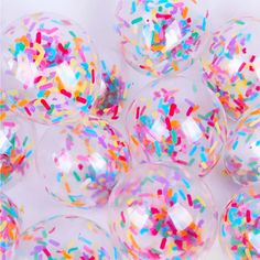 colorful sprinkles on clear plastic balls with white background