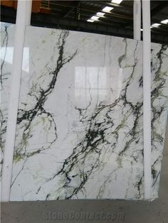 white marble with black veining and green veinies on the edges, in a warehouse