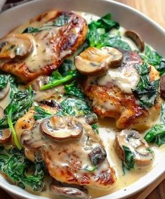 chicken with mushrooms and spinach in a white bowl on a wooden table, ready to be eaten