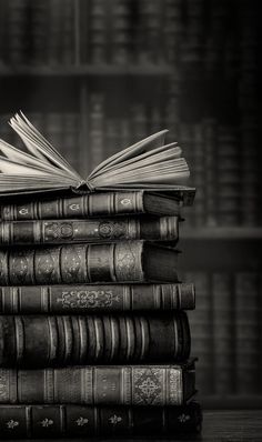 a stack of books sitting on top of each other in front of a bookcase