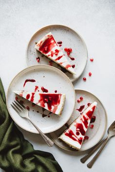 three plates with slices of cheesecake covered in red and white icing on them