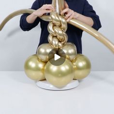 a young boy is holding onto some gold balls and a large metal object in front of him