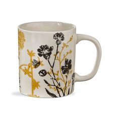 a white coffee mug with black and yellow flowers on it