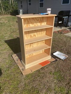 a wooden book shelf sitting in the grass