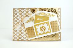 a close up of a card with gold foil on it and white paper in the background