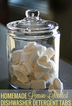 homemade lemon - scented dishwasher deterent tabs in a glass jar with text overlay