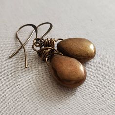 "Bronze Glass Teardrop Earrings, Rustic Bronze Brown Earrings, Rustic Bronze Earrings, Brass, Boho, Wire Wrapped You have to admire the simplicity of these glittery bronze glass drops. I took these these gorgeous bronze glass teardrops and minimally wired them in antiqued bronze copper core wire. I hung from hypoallergenic antiqued brass earwires. From the top of the leverback wires earrings fall 1.5 inches or the artisan french hooks, 1.75 inches. Choose your preferred earwire at checkout. Bead Adjustable Teardrop Pendant Earrings As Gift, Bronze Nickel-free Drop Earrings, Bronze Metal Teardrop Earrings, Handmade Bronze Teardrop Earrings, Bronze Teardrop Earrings For Gifting, Bronze Teardrop Earrings For Gifts, Teardrop Bronze Earrings For Gift, Adjustable Metal Teardrop Earrings Gift, Adjustable Metal Teardrop Earrings For Gift