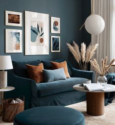 a living room with blue couches and pictures on the wall above them, as well as a round coffee table