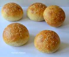 six buns with sesame seeds on them sitting on a white counter top next to each other