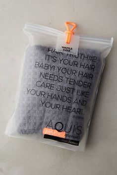 an orange and white toothbrush in a plastic bag on a table with the words, it's your hair baby you're tender care just like your hands and your hair