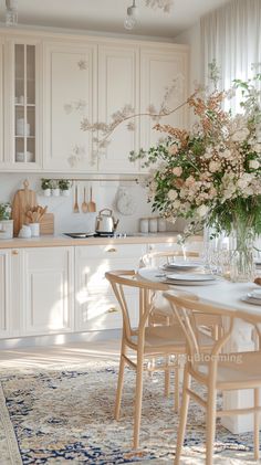 a dining room table and chairs in front of a vase with flowers on the table