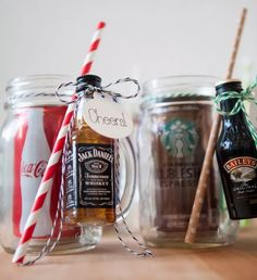 three mason jars filled with different types of drinks and candy canes on top of a wooden table