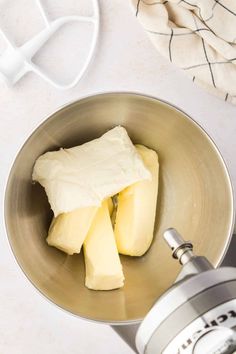 a metal bowl filled with butter next to a blender