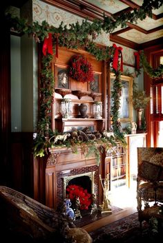 a living room decorated for christmas with wreaths on the mantle