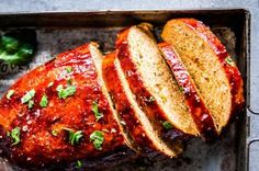 sliced meatloaf with marinara sauce and parsley on top in a baking pan