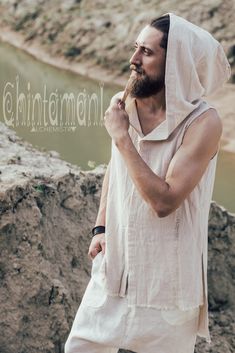 "⫸ We ship by EXPRESS EMS now for fast & safe delivery! This white long sleeveless man shirt with a huge hood is a very bohemian, yet classy piece from our raw cotton collection. It is made out of 100% raw cotton - very light, soft, breathable fabric, that looks gorgeously natural. In this shirt the beauty of raw fabric is manifested through original design. Hemline is open, front and back are asymmetrically decorated with long handmade rips; soft huge hood creates very cozy feeling. We make Bohemian Hooded Top For Summer, Bohemian Outfit Men, Summer Looks For Men, Men Streetwear Outfits, Men Boho, Turkish Clothing, Long Tank Top, Raw Fabric, Mens Summer Outfits