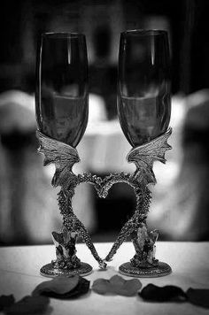 two wine glasses sitting next to each other on top of a table with a heart in the middle