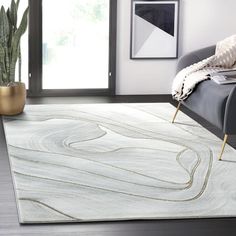 a living room area with a couch, rug and potted plant on the floor