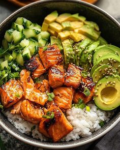 a bowl filled with salmon, avocado and rice on top of a table