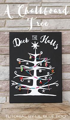 a chalkboard christmas tree is hanging on the wall