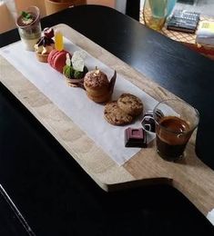 a wooden tray topped with pastries on top of a table