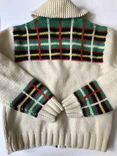 a white sweater with green, yellow and red stripes