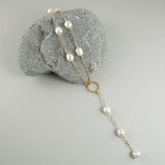 This lariat style white pearl necklace will turn heads. It is simply gorgeous. Made with white freshwater rice pearls that are individually hand wire wrapped onto 14k gold filled chain, and fastens with a 14k gold filled lobster clasp. The necklace showcases a round hammered 14k gold filled connector that sits right at the dip at the bottom of the neck and has a lovely 3.25 inch pearl and chain dangle that drops enticingly down into the décolletage area. A very sexy necklace that will compliment White Pearl Chain Lariat Necklace, Pearl White Lariat Necklace Gift, Pearl White Lariat Necklace As Gift, Pearl Lariat Necklace With Adjustable Chain, White Lariat Necklace Gift, White Pearl Pendant Lariat Necklace, Pearl White Pearl Lariat Necklace, White Pearl Lariat Necklace, White Lariat Necklace With Pearl Pendant