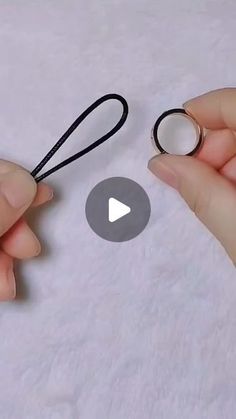 two hands are holding scissors and string