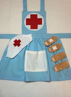 a child's apron and shoes made to look like a nurse uniform with red cross on it