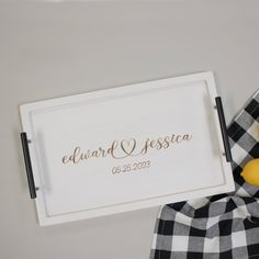 a white tray with a yellow lemon on it and a plaid blanket next to it