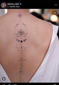 the back of a woman's neck with an intricate tattoo design on her lower back