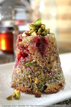 a small dessert on a white plate with sugar and sprinkles around it