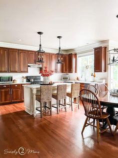 a kitchen filled with lots of wooden furniture next to a dining room table and chairs