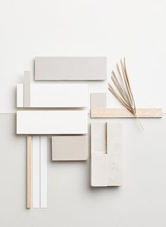 an assortment of white and beige objects on a white surface with sticks sticking out of them