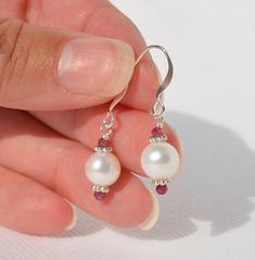 Genuine Freshwater Pearl Earrings with Pink Tourmaline or Red Tourmaline gemstone accents - Authentic White Pearl Jewelry - Handmade Earrings - Pearl is June's Birthstone and Pink Tourmaline is October's Birthstone - Everyday Earrings - Elegant earrings - Silver-plated ear wire and spacer beads - Multiple styles: (1)  8mm round white Freshwater Pearls with 2mm Red Tourmaline gemstone accents - Overall earring length is 1.2 inches (15) (2)  8mm round white Freshwater Pearls with 2mm Red Tourmaline gemstone accents - Overall earring length is 1.1 inches (11) (3)  7mm round white Freshwater Pearls with 2mm Red Tourmaline gemstone accents - Overall earring length is 1.1 inches (14) (4)  9mm round blush Freshwater Pearls with 2mm Red Tourmaline gemstone accents - Overall earring length is 1.15 Red Pearl Drop Jewelry For Anniversary, Anniversary Jewelry With Matching Round Bead Earrings, Elegant Red Birthstone Gemstones, White Ruby Round Earrings, Classic Jewelry With Birthstones For Jewelry Making, White Crystal Gemstone Earrings For Gift, White Gemstone Crystal Earrings For Gift, Formal Dangle Birthstone Jewelry, Elegant Round Crystal Birthstone Earrings