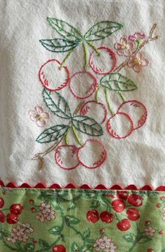 an embroidered piece of cloth with cherries on it