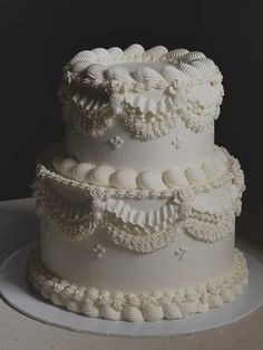 a three tiered white wedding cake sitting on top of a table