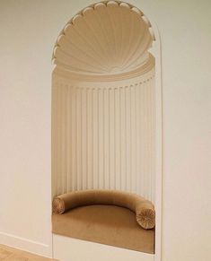 a curved bench sitting under a window in a room