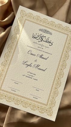 an arabic wedding card on top of a bed