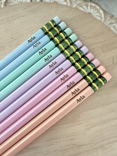 six pastel colored pencils with names on them