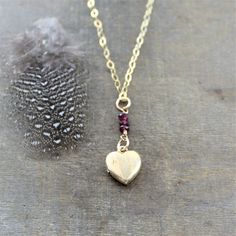 "A tiny vintage locket sways beneath a little stack of gems. The gold filled pendant find opens to reveal two recessed areas ready for your beloved photographs to be placed inside. The heart shaped pendant dangles from a stack of tiny garnet gemstones (if you prefer a different gemstone make your selection at checkout) and is set on a new 14k gold filled finished with a lobster clasp. Locket 13mm Necklace length 18\" (45cm) ✤Our entire selection of lockets can be found here: http://www.etsy.com/ Valentine's Day Gold Locket Jewelry, Elegant Brass Locket Necklace For Valentine's Day, Valentine's Day Brass Locket Necklace, Valentine's Day Gold-plated Locket Jewelry, Tiny Locket, Gold Heart Locket Necklace, Heart-shaped Brass Locket Necklace For Gifts, Locket Gold, Push Gifts