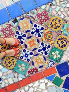 someone is painting the floor with colorful tiles